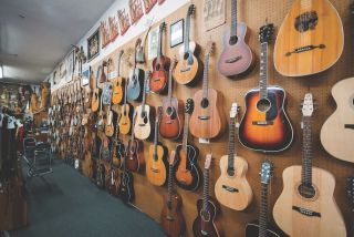 Acoustic guitars of many makes, sizes, and eras line a wall at the Folk Music Center