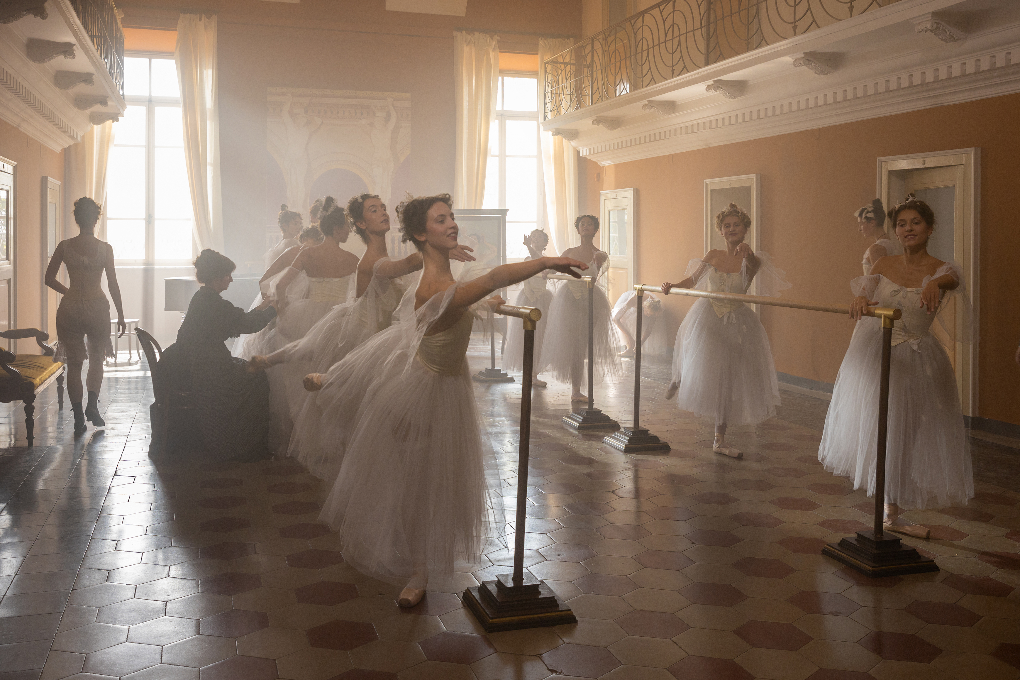 A group of ballet dancers doing barre rehearsal in a studio