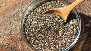 Chia seeds in bowl with wooden spoon