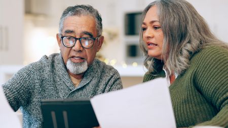 Senior couple looking through documents at home
