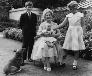 Queen Elizabeth the Queen Mother in the garden of Clarence House on the occasion of her 60th birthday, with her grandchildren Prince Charles, Princess Anne, and Prince Andrew, who is almost 6 months old