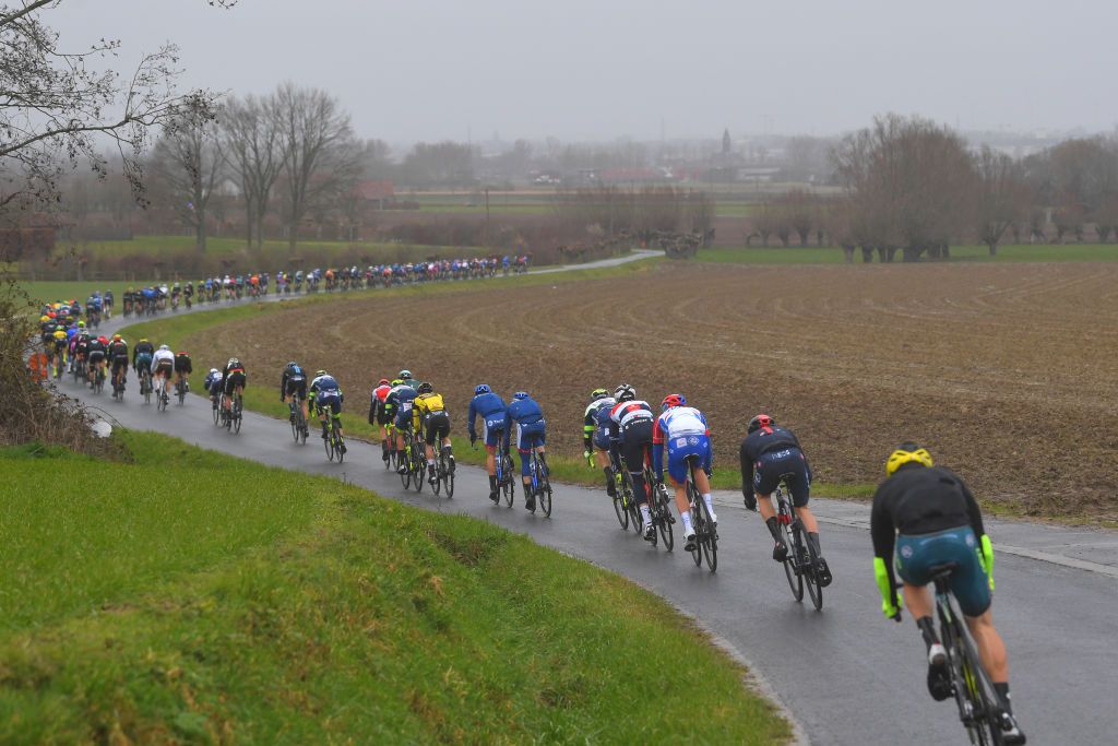 NOKERE BELGIUM MARCH 17 The peloton during the 75th Nokere Koerse Danilith Classic 2021 Mens Elite a 1955km race from Deinze to Nokere Rain Fog Landscape NokereKoerse on March 17 2021 in Nokere Belgium Photo by Luc ClaessenGetty Images