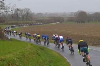 NOKERE BELGIUM MARCH 17 The peloton during the 75th Nokere Koerse Danilith Classic 2021 Mens Elite a 1955km race from Deinze to Nokere Rain Fog Landscape NokereKoerse on March 17 2021 in Nokere Belgium Photo by Luc ClaessenGetty Images