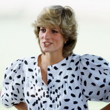Princess Diana wears a black and white spotted shirt with baggy sleeves and has short blonde bouffant hair