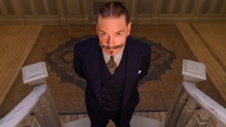 Kenneth Branagh stares ominously on a staircase in Death on the Nile.