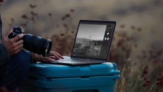 A picture of a photographer using the 2020 Apple MacBook Pro 13in in the field