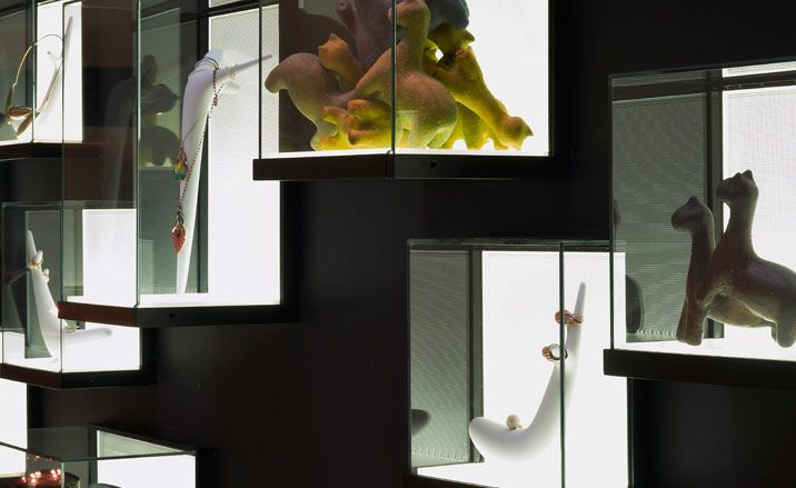 Beside the Corian ribbon, the gallery’s jewelry collection and small objects are displayed in illuminated, wall-mounted boxes.