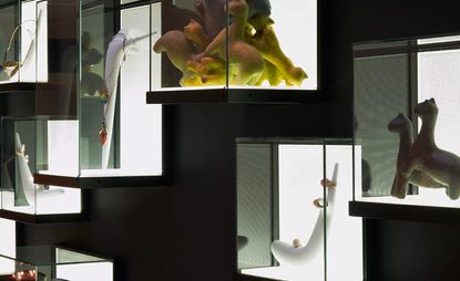 Beside the Corian ribbon, the gallery’s jewelry collection and small objects are displayed in illuminated, wall-mounted boxes. 