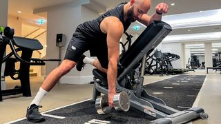Calum Sharma, personal trainer at the Body Lab, performing the first step of an incline single-arm row