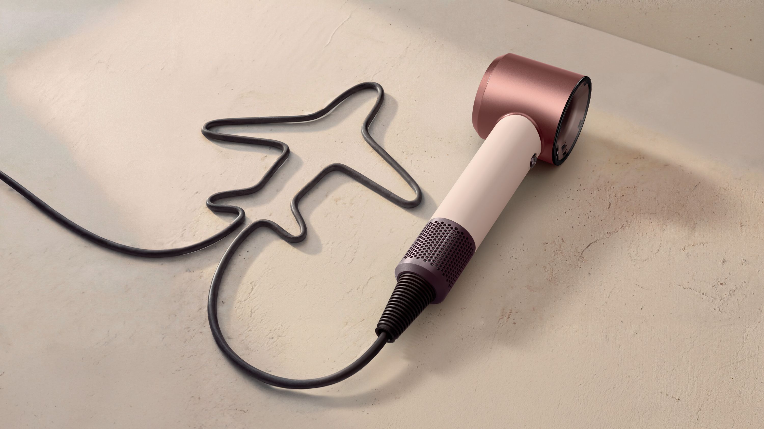 Dyson Supersonic Travel hair dryer with cable arranged in the shape of a plane