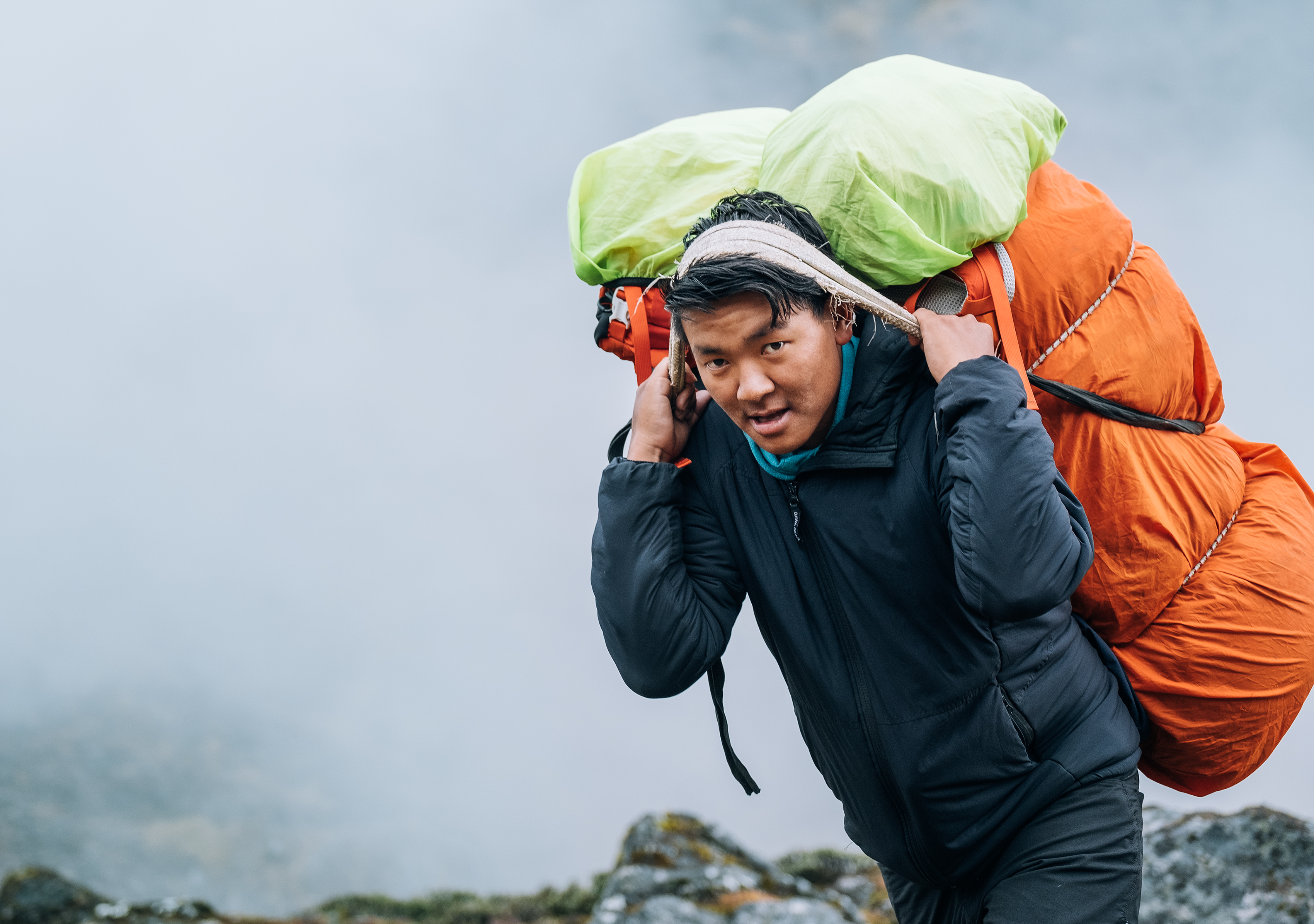 Sherpa carrying gear in the traditional way