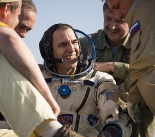 NASA astronaut Rick Mastracchio, an Expedition 39 flight engineer, smiles as he is helped out of a Soyuz TMA-11M spacecraft just minutes after returning to Earth on May 14, 2014.