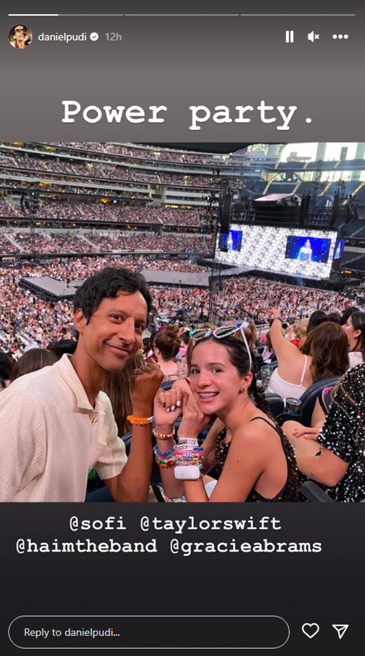 Danny Pudi and his daughter smiling for a selfie at the Eras Tour.