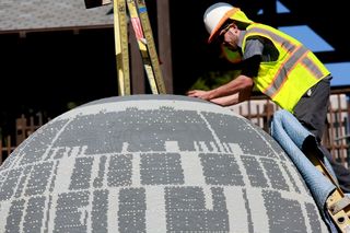 A worker at LEGOLAND California puts together the "Star Wars" Miniland Death Star before the opening on March 5, 2015.