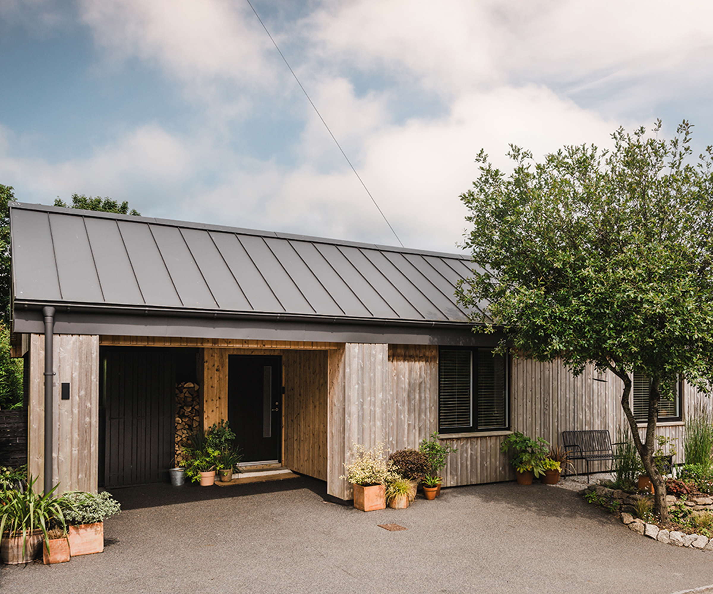Exterior of a cottage renovation clad in timber with a warm roof