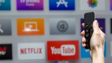 Human hand holding a remote control and browsing their streaming service selections