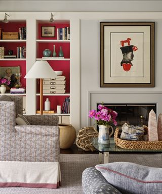 sticking to a budget, red and pale grey living room with red bookcase, patterned armchair, floor light, rug, artwork