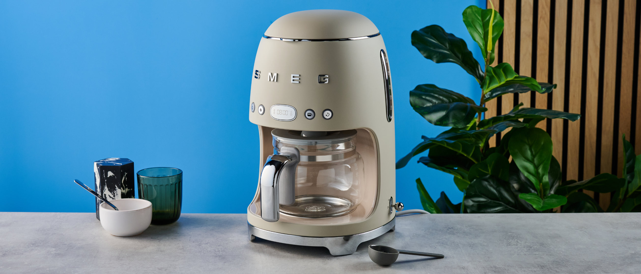 the smeg retro coffee maker photographed against the blue tom's guide background
