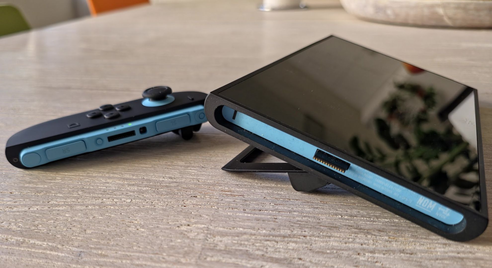 A Nintendo Switch 2 laying on its stand in front of a controller