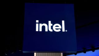 An illuminated Intel logo shot from below against a dark ceiling