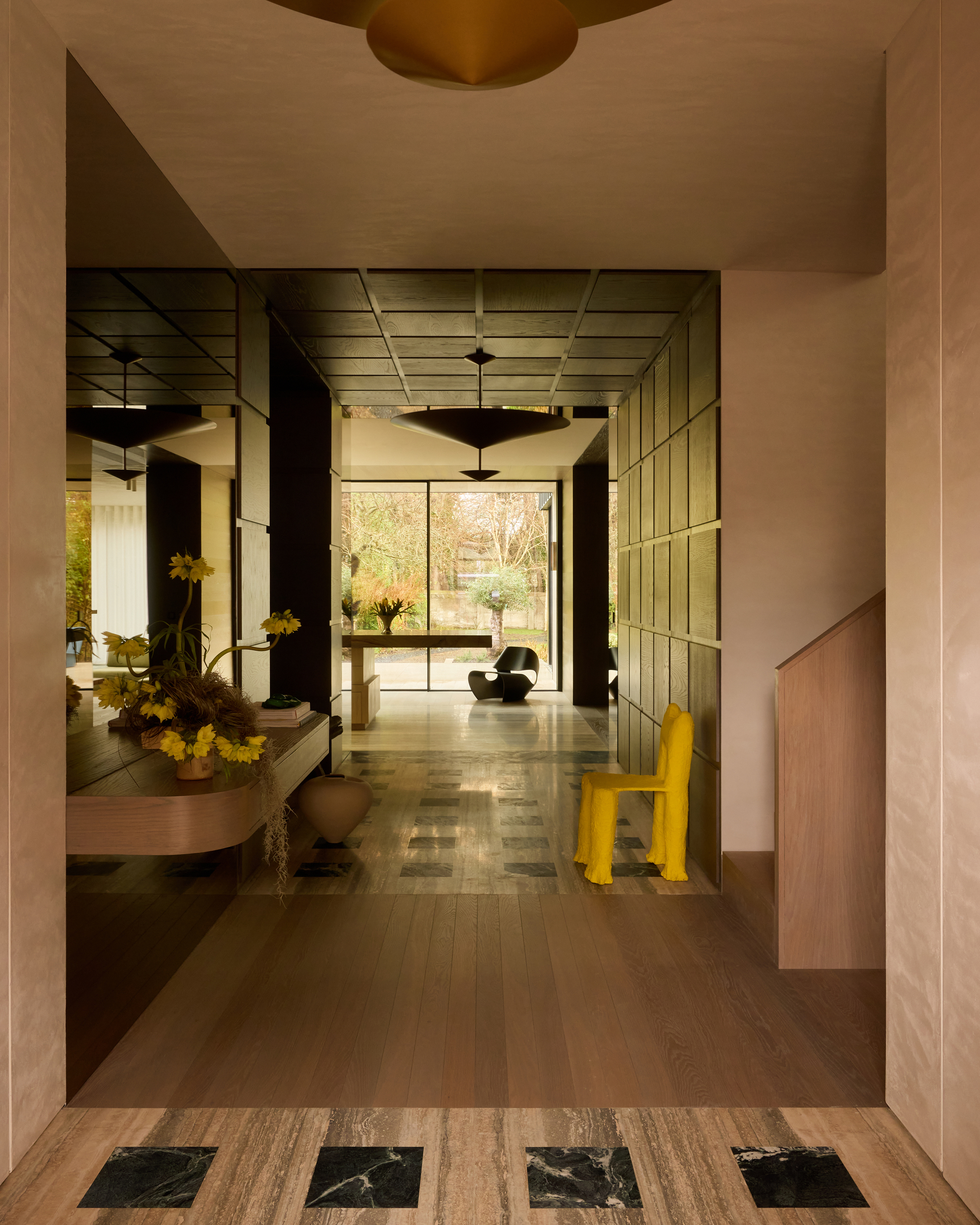 A large entryway with a mix of materials. There is a warm neutral colorway with marble in doorways.