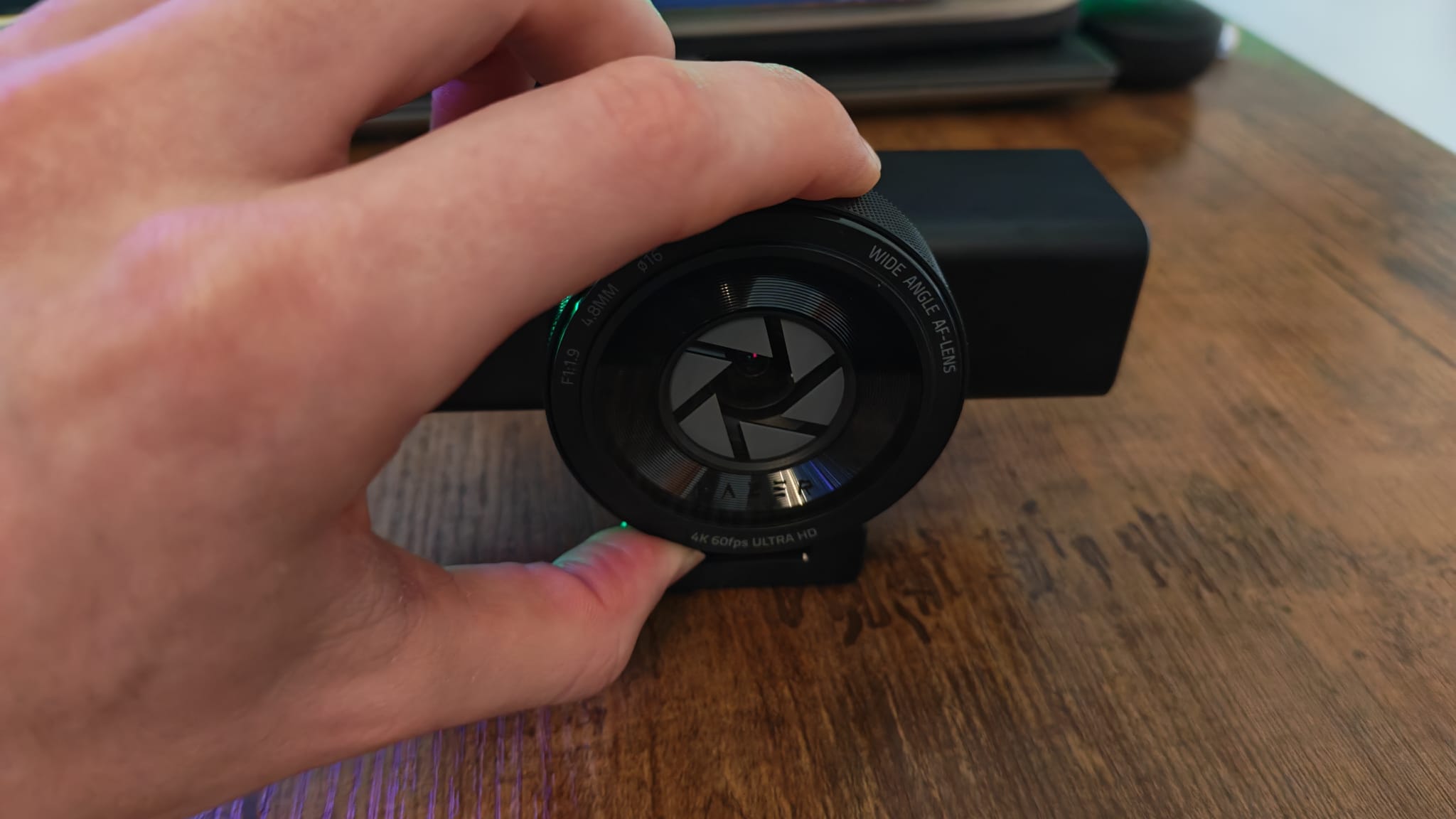 A reviewer twisting the lens cover on the Razer Kiyo V2 Pro