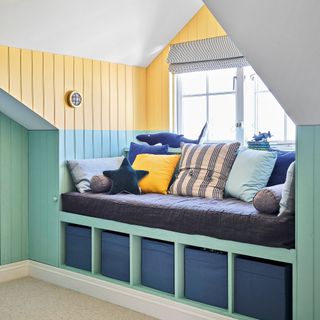 Bedroom window seat with panelled walls painted blue and yellow