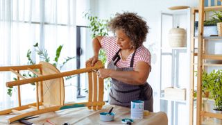 A woman fixes a broken chair