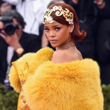 rihanna wears a gold headpiece and a yellow fur cape
