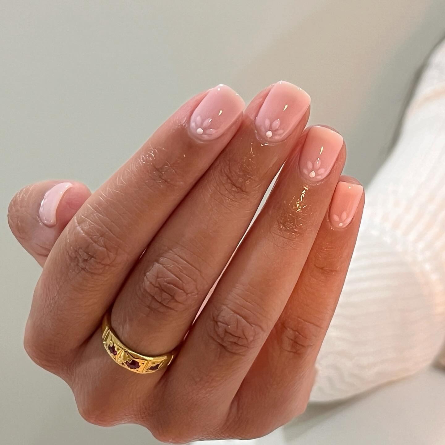 Short, pale pink nails with petal nail art