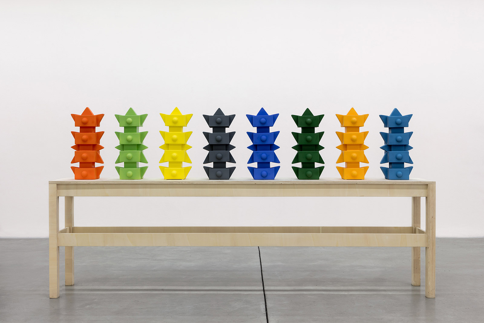 Coloured, geometric objects lined up along a table