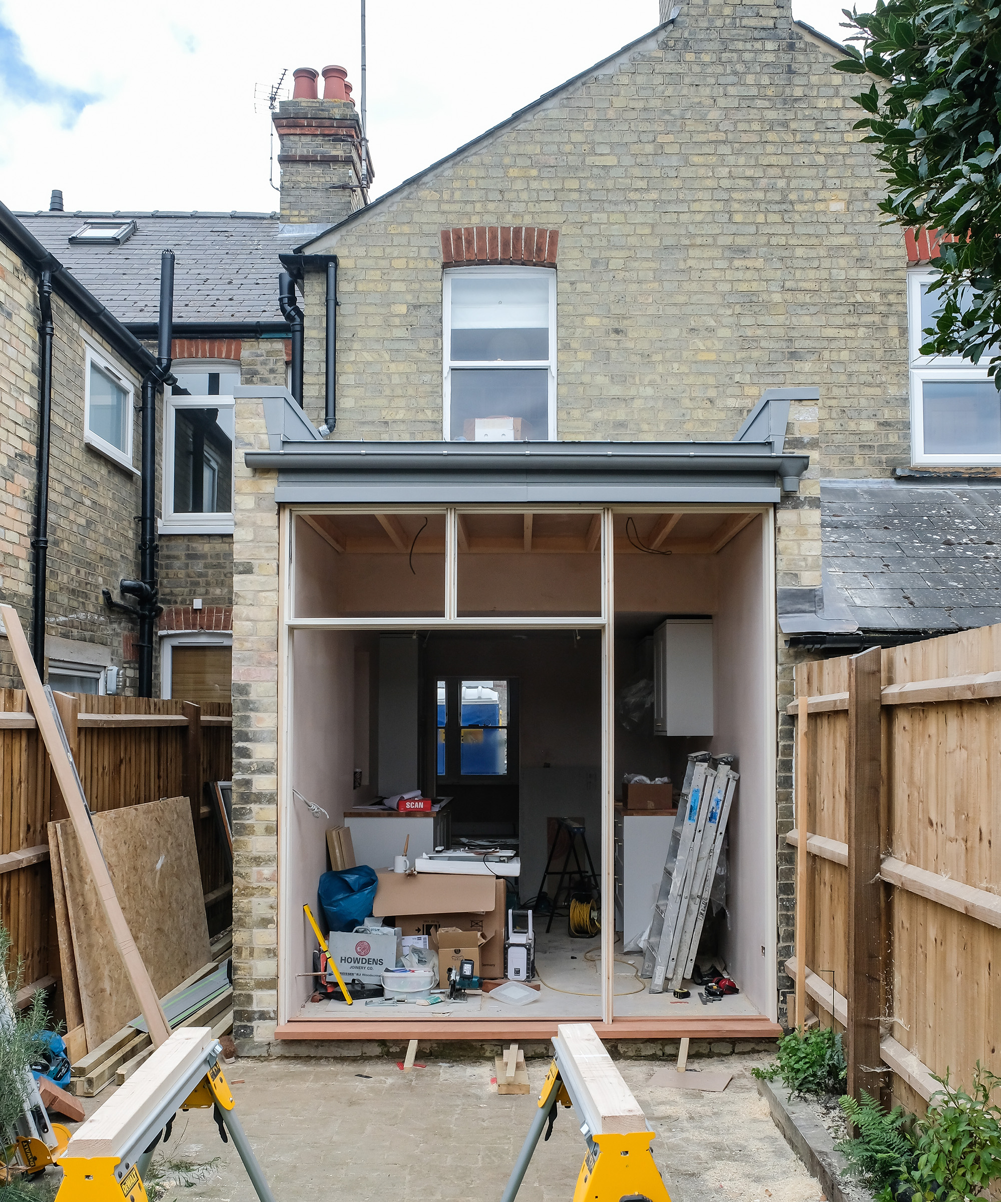 Progress shot of a narrow kitchen extension with the timber frame put in for glazing and French doors