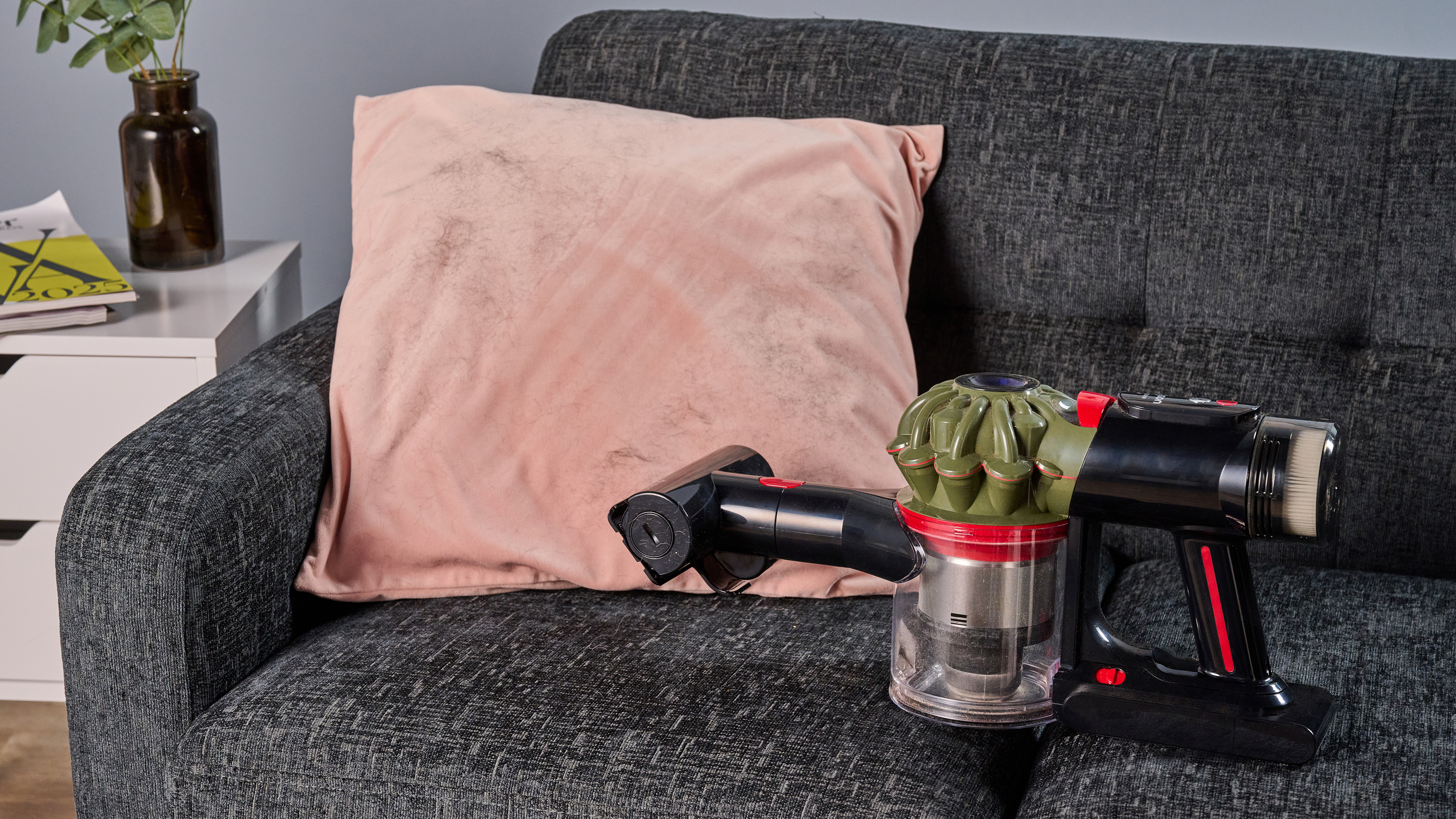 Dyson V8 Cyclone vacuum in handheld mode, having cleared dog hair from a cushion