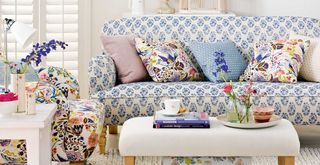 white living room with patterned sofa and armchair to support common mistakes when buying a sofa of neglecting pattern