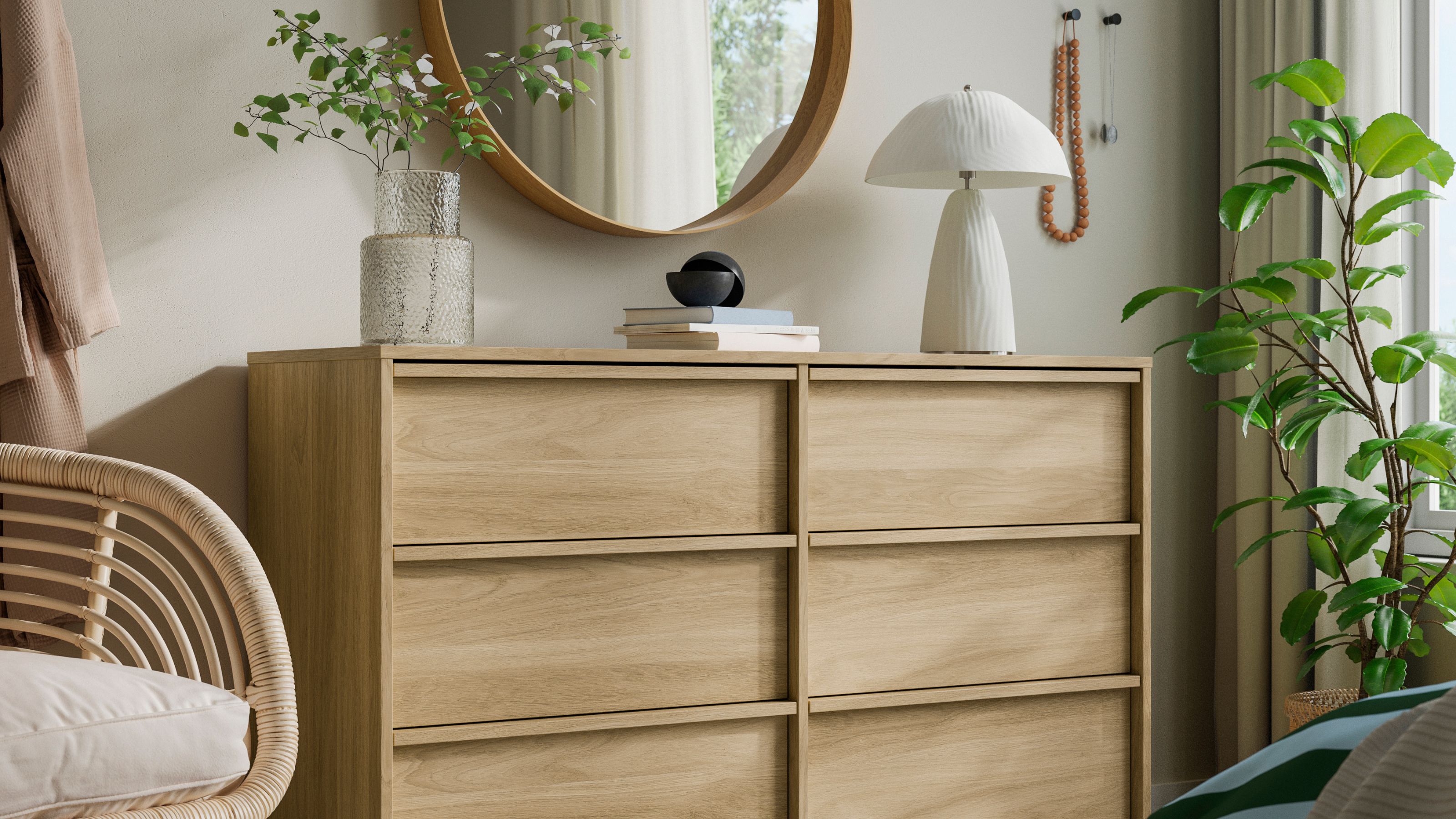 IKEA ANKARUDDEN Chest of 6 Drawers styled in bedroom with a lamp, vase of branches, and books, under a round mirror, next to a plant, and a cane armchair