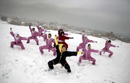 Shaolin martial arts students follow their trainer, Sima Azimi, 20, in black, during a training session on a hilltop in Kabul, Afghanistan on Jan. 25, 2017.