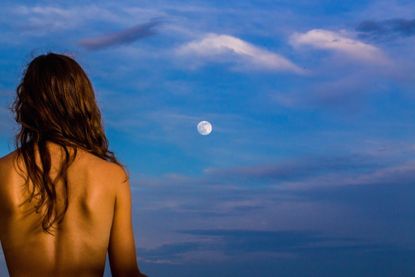 Rear View Of Young Woman Against Cloudy Sky During Sunset