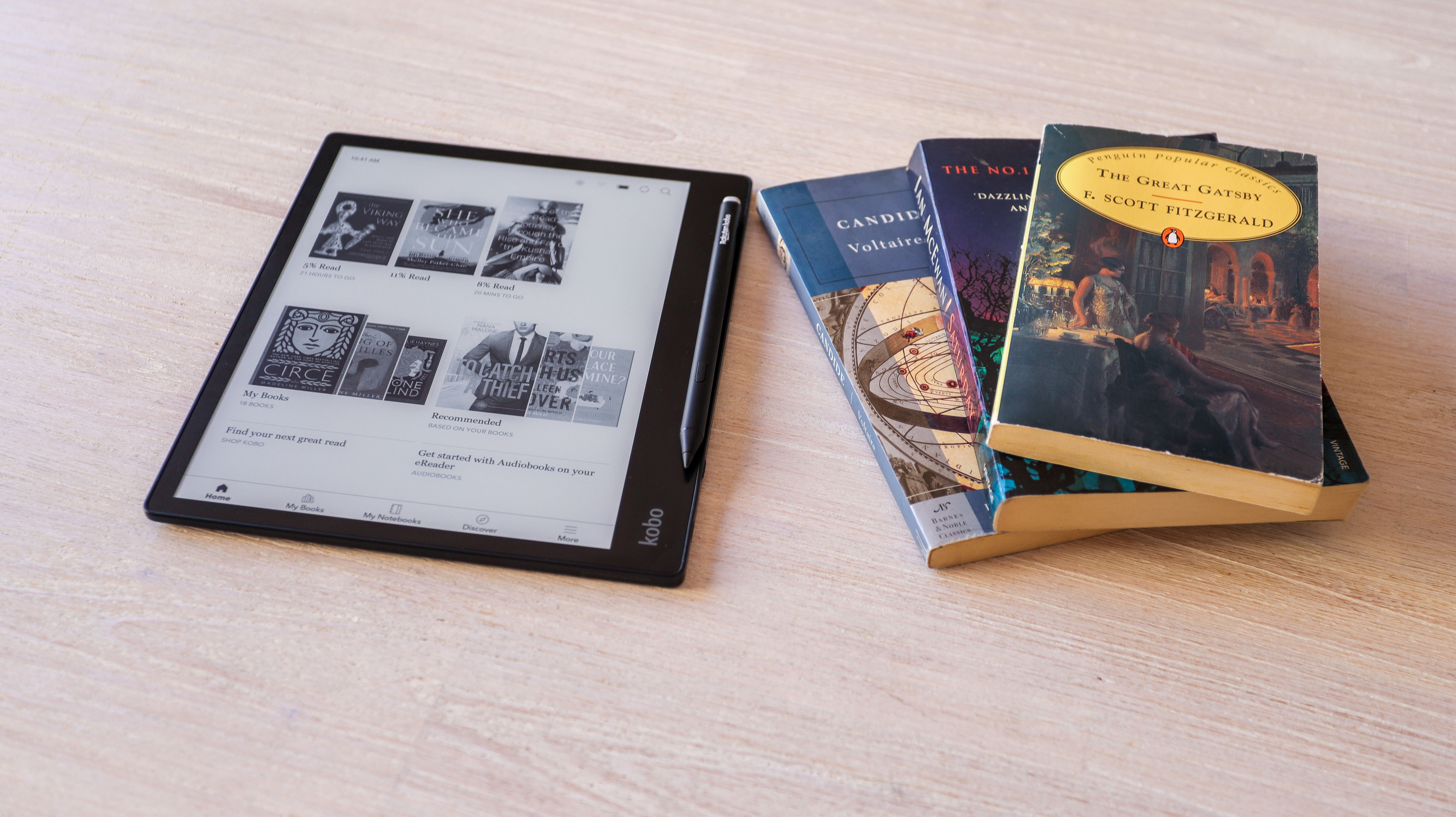 The Kobo Elipsa 2E со стилусом на столе рядом с книгами