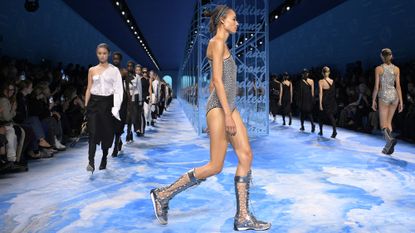 Dior Spring/Summer 2025 models walk down the runway in the finale, wearing glittering swimsuits, white shirts and black trousers