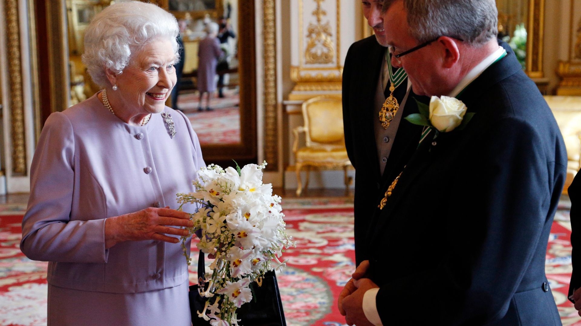 Queen Elizabeth II is presented with a replica of the Coronation Bouquet by the Worshipful Company of Gardeners in the White Drawing Room at Buckingham Palace on May 30, 2013