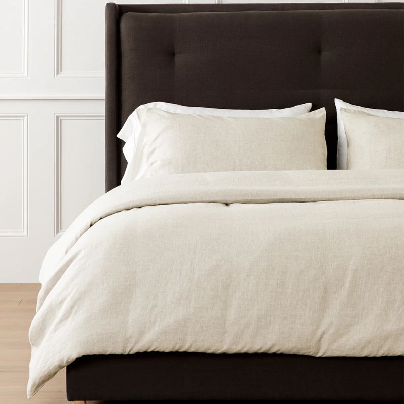 neutral bedcover on dark brown bed