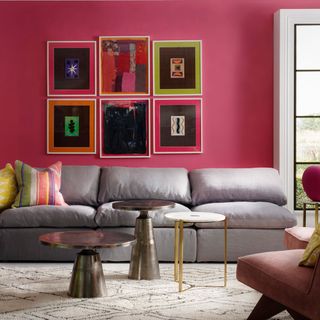 living area with pink wall and grey sofa and coffee table