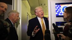 President Donald Trump talks to reporters on Air Force One