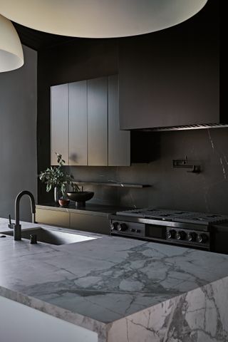 matte black kitchen units with a marble island and black fixtures