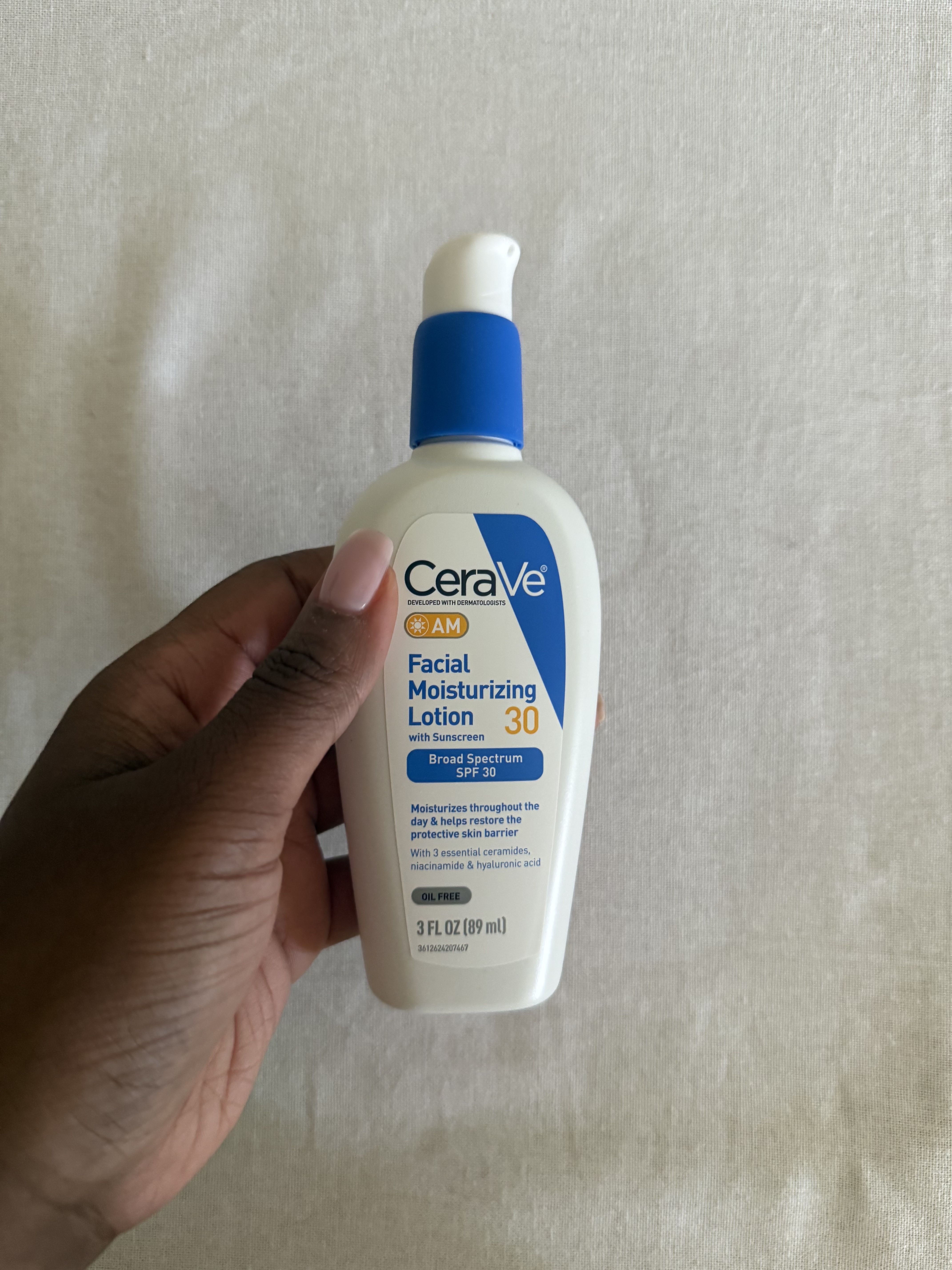 Associate Beauty Editor Maya Thomas holding CeraVe Facial Moisturizing Lotion SPF 30
