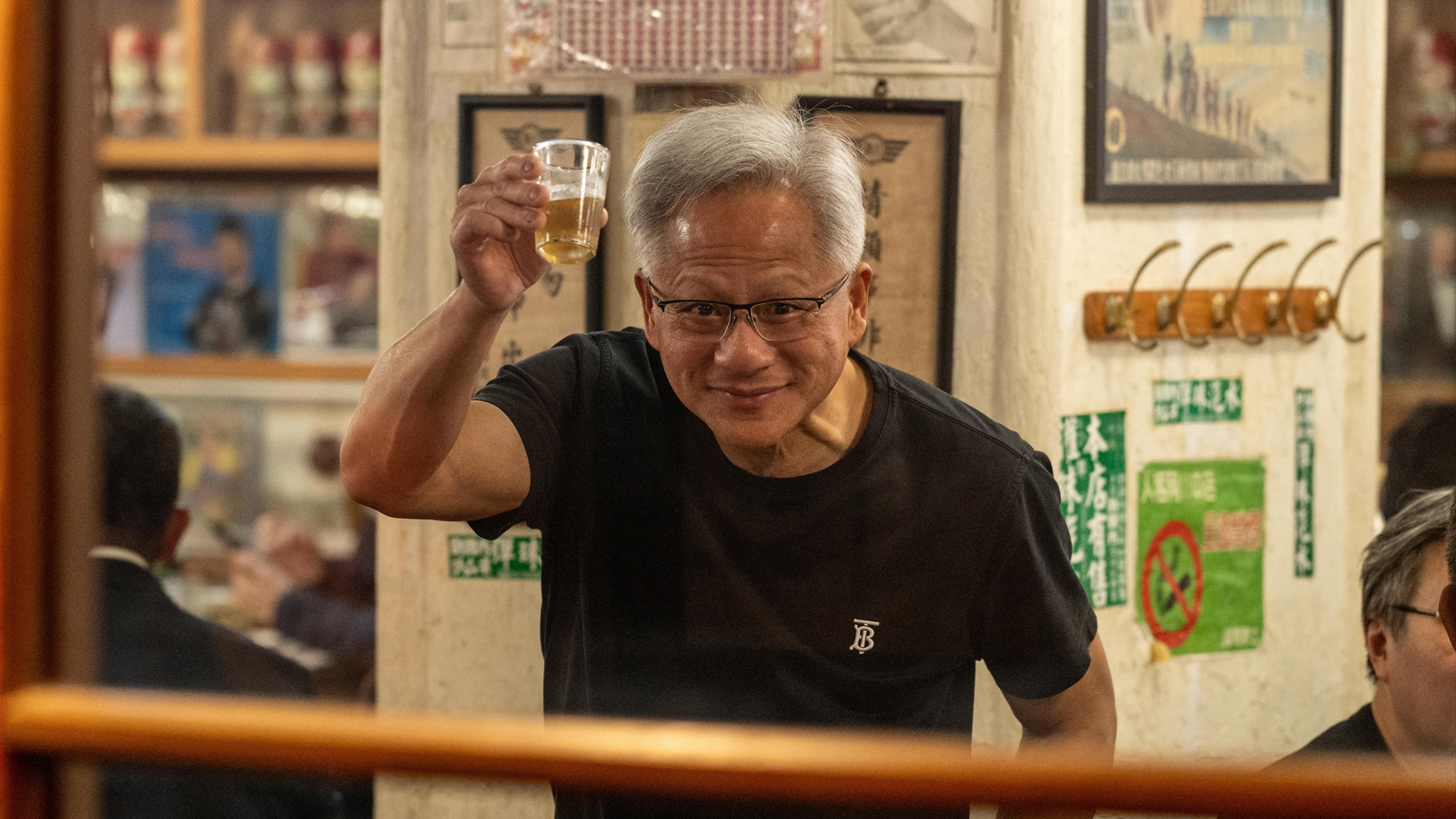 Jensen Huang toasting the camera person with a beer.