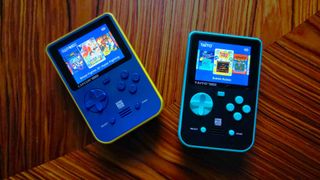 Capcom and Taito Super Pocket handhelds on woodgrain table