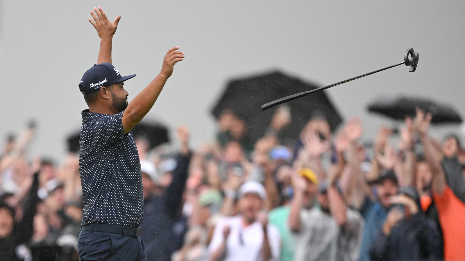 JJ Spaun throws his putter after holing a putt