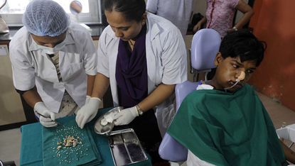 Dentists display teeth removed after operating on seventeen year old Ashik Gavai at JJ Hospital in Mumbai