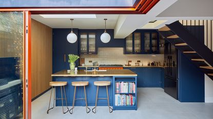 a kitchen island with breakfast bar and a row of three bar stools